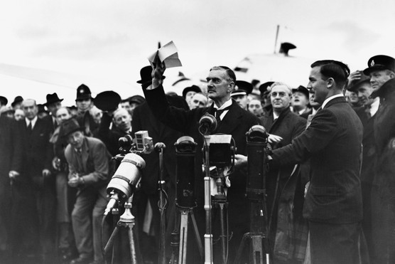 Prime Minister Neville Chamberlain waves to the crowd at Heston Airport and declaims "Peace in our Time" after returning from signing the Munich Agreement. (Photo by © Hulton-Deutsch Collection/CORBIS/Corbis via Getty Images)