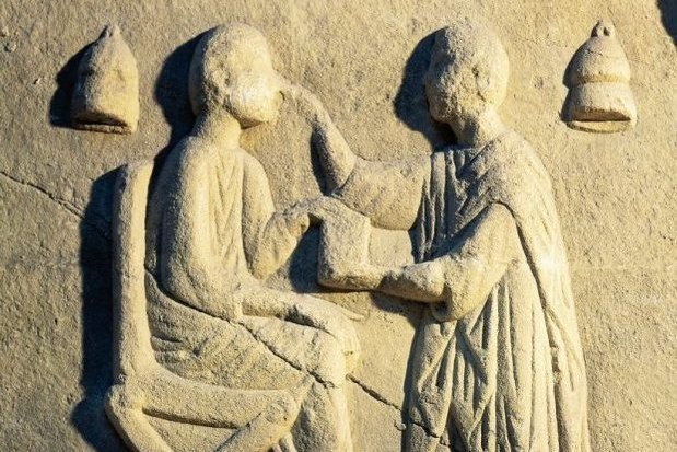 A Roman relief portraying an ophthalmologist examining a patient A Roman relief portraying an ophthalmologist examining a patient