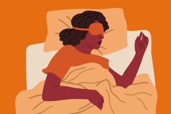 Woman sleeping in night mask lying on bed.