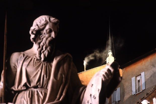 White smoke from the Vatican let's the outside world know that a new pope has been chosen (Photo via Getty) A statue in the foreground, a chimney emitting white smoke in the background