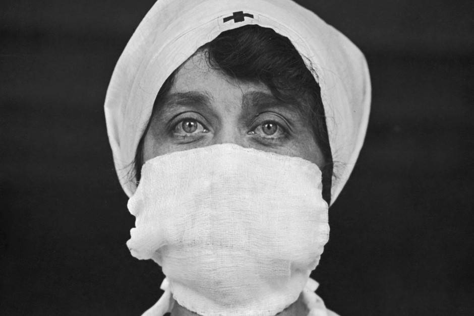 A Red Cross worker in the United States wears a mask to reduce the risk of contracting or spreading the disease in 1918. Though doctors didn’t initially understand the nature of the infectious agent, ‘social distancing’ helped slow the propagation of the flu. (Photo by Paul Thompson/FPG/Hulton Archive/Getty Images) A Red Cross worker in the United States, 1918