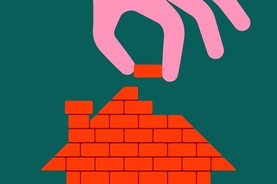 Human hand holding a brick, building a house step by step.