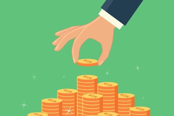 Hand placing a coin on a tower.