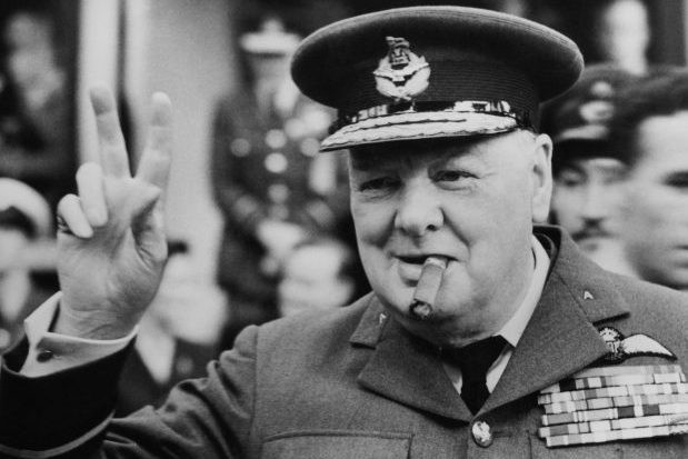 Winston Churchill gives his famous v-sign as he opens the new headquarters of 615 (County of Surrey) Squadron of the RAAF (Royal Auxiliary Air Force) at Croydon, 1948. (Photo by Central Press/Hulton Archive/Getty Images)